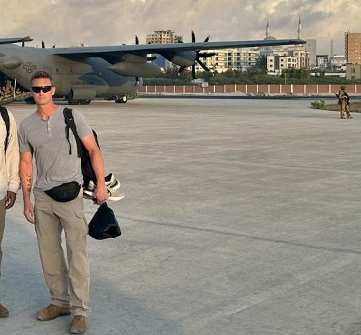 Standing in front of aircraft at forward operating airfield